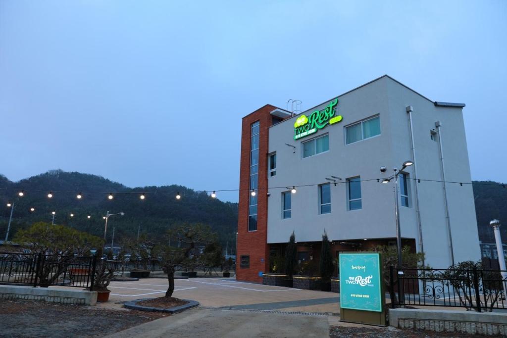 a building with a sign on the side of it at Two Rest Pension in Damyang