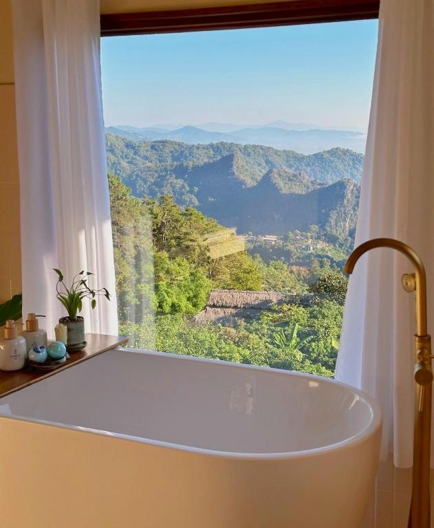 a bath tub in a bathroom with a large window at Sayu Homestay&Cafe in Ban Pha Mi