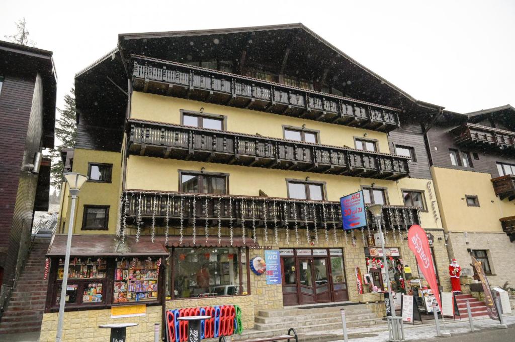 ein Gebäude mit einem Balkon auf dem Dach in der Unterkunft Casa Frent in Predeal