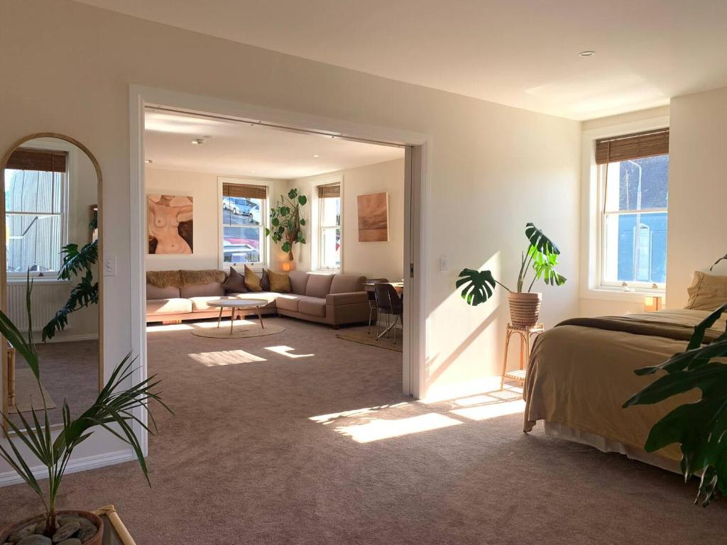 een slaapkamer met een bed en een woonkamer bij The Painters Loft in Dunedin