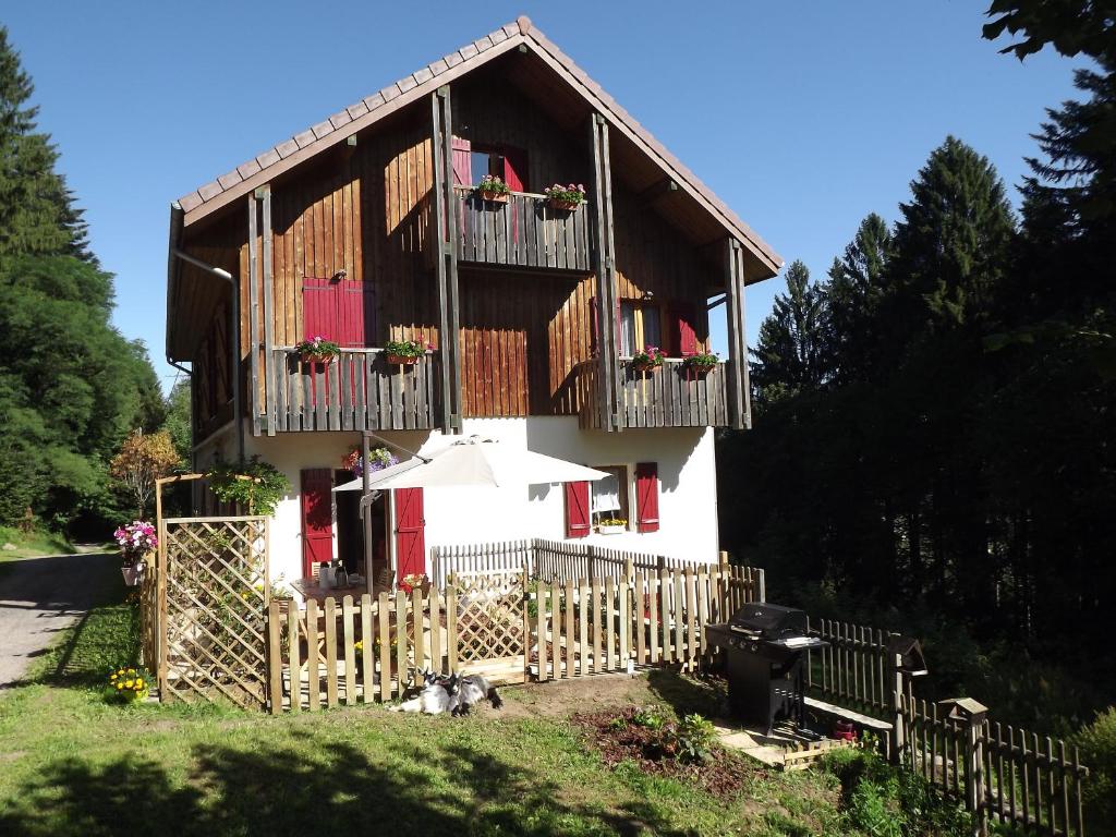 a house with a fence and an umbrella in front of it at Le Haut Van in Fraize