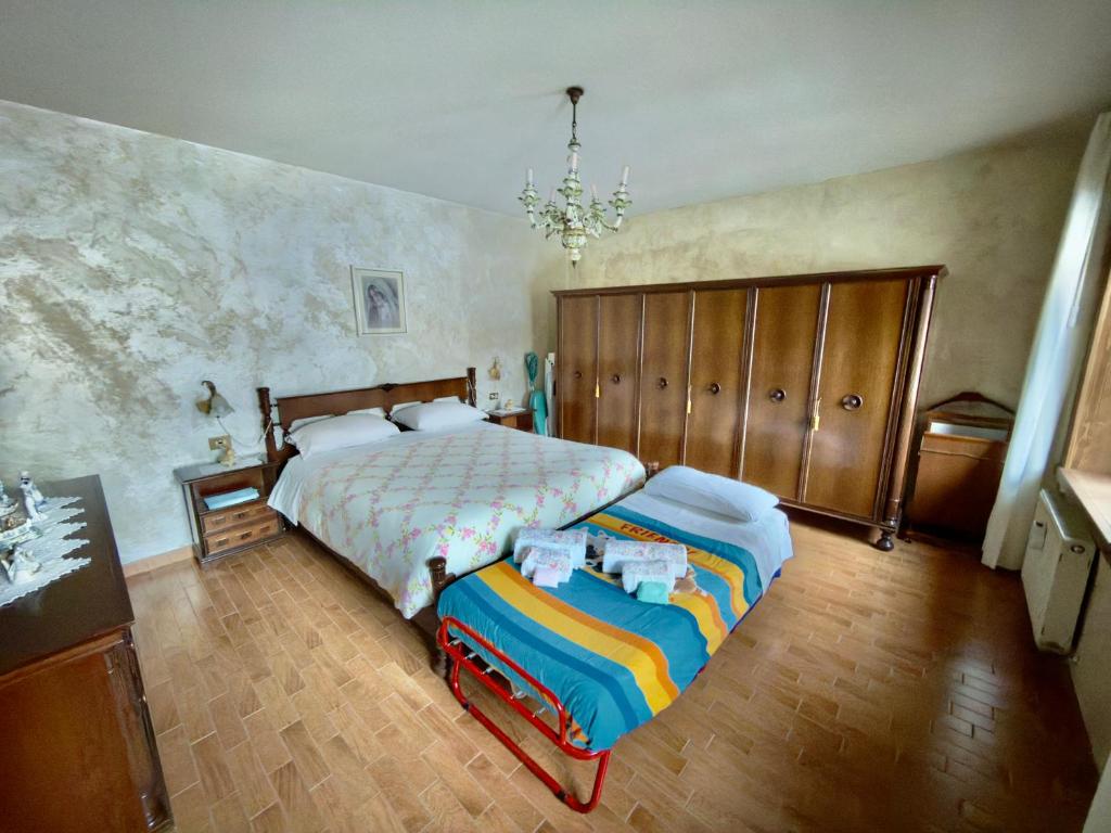 een slaapkamer met een bed en een kroonluchter bij Casa Bagatin in Santo Stefano di Cadore