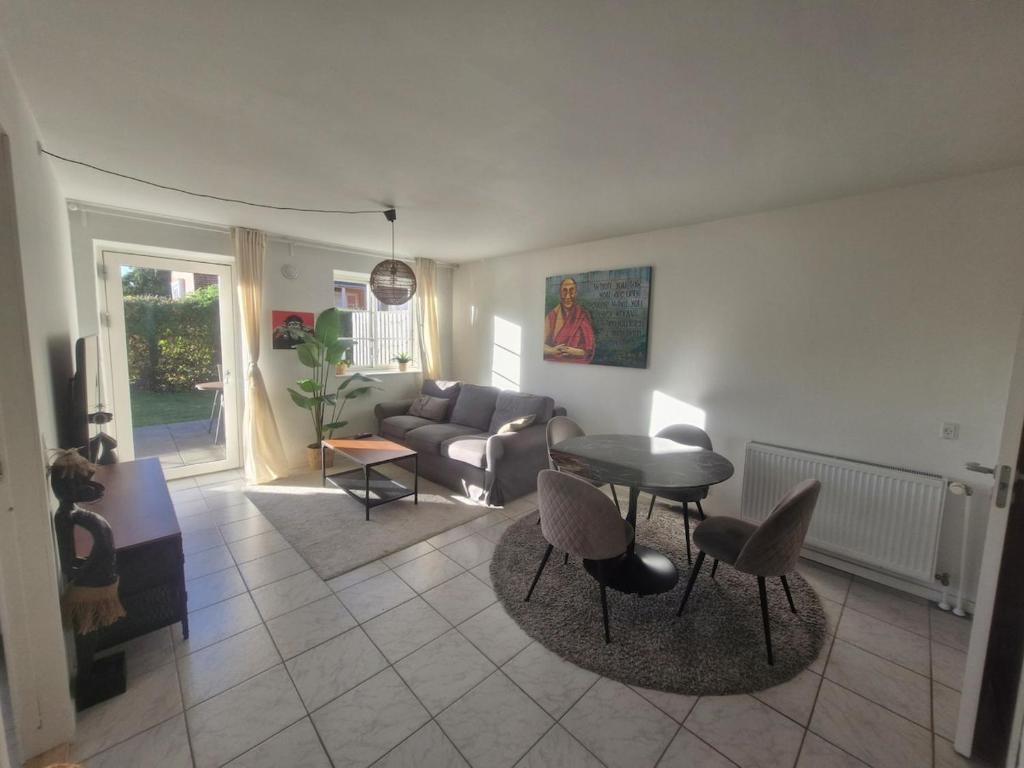 a living room with a couch and a table and chairs at Cozy Airport stay in Copenhagen