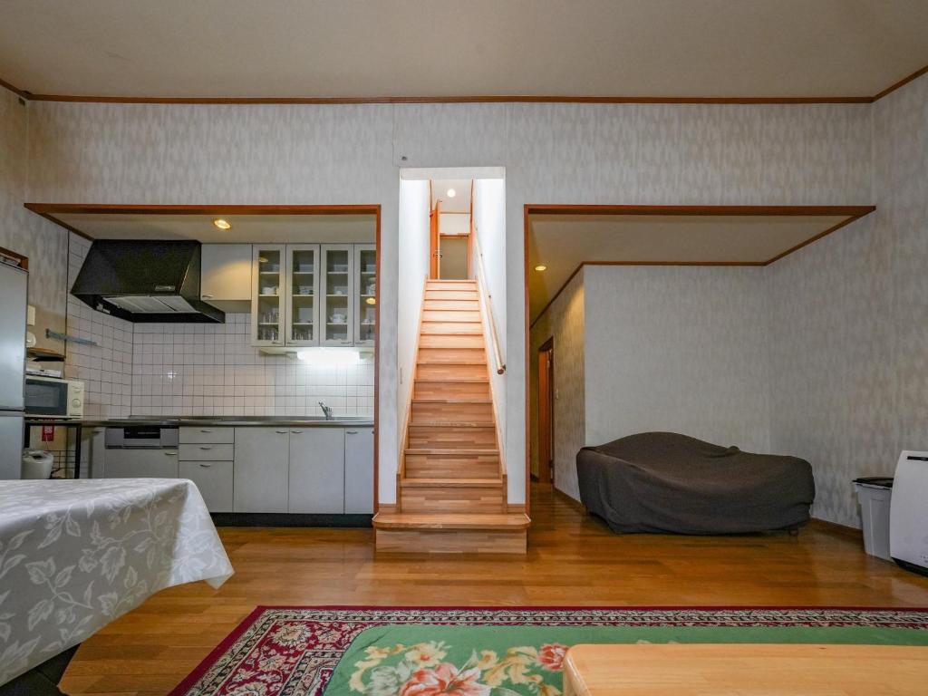 een woonkamer met een trap naar een keuken bij Runesu Karuizawa - Vacation STAY 78428v in Tsumagoi