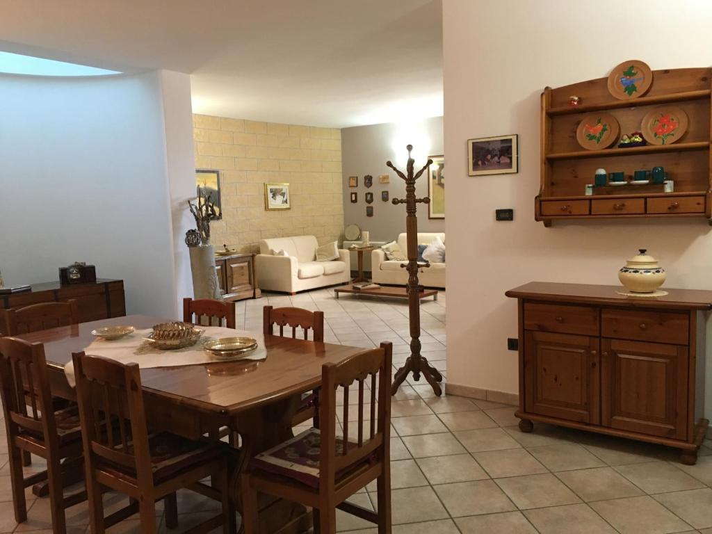 uma sala de jantar com uma mesa e uma sala de estar em Villa Abati em Collepasso