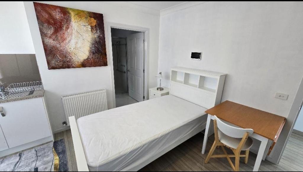 een kleine slaapkamer met een bed, een tafel en een schilderij bij Luxary accommodation in Clayton North