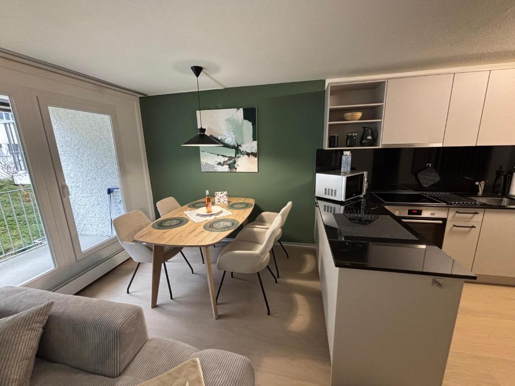 une cuisine et une salle à manger avec une table et des chaises dans l'établissement Feel Home Apartments - Seeblick - Bergblick - Parkplatz, à Emmetten