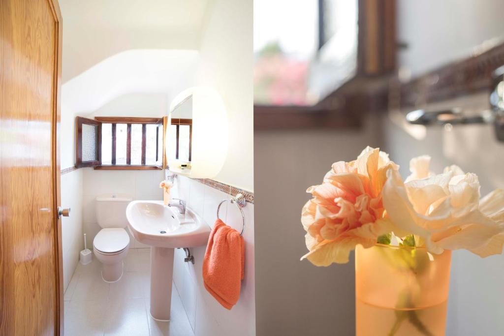 プエルト・デル・カルメンにあるDuplex Joanのバスルーム(洗面台、花瓶入りの花付)
