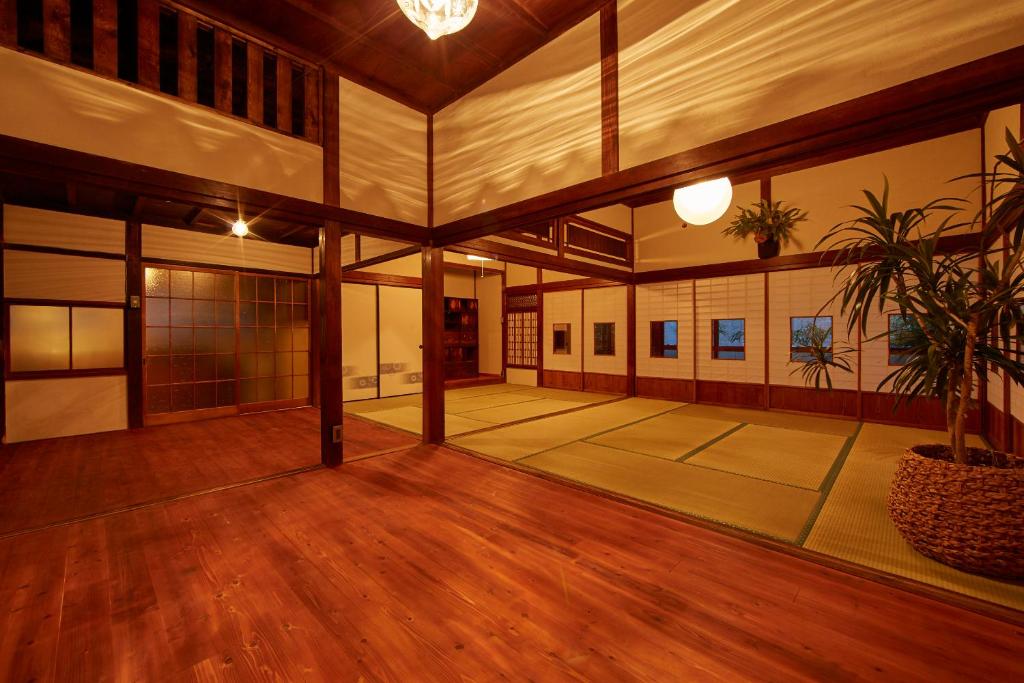 um quarto amplo com pisos em madeira e um vaso de plantas em Minato-no Akari em Hayama