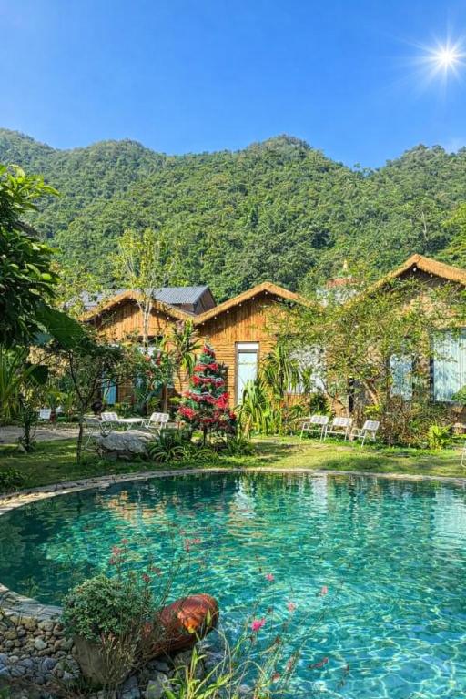 a house with a swimming pool with mountains in the background at Mộc Sơn Homestay in Mộc Châu