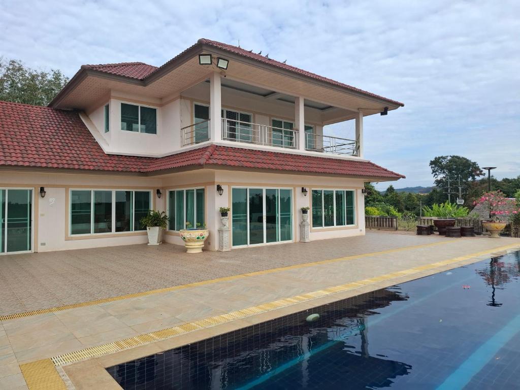 a house with a swimming pool in front of it at Cozy Country House with Pool in Ban Nong Nam Khem