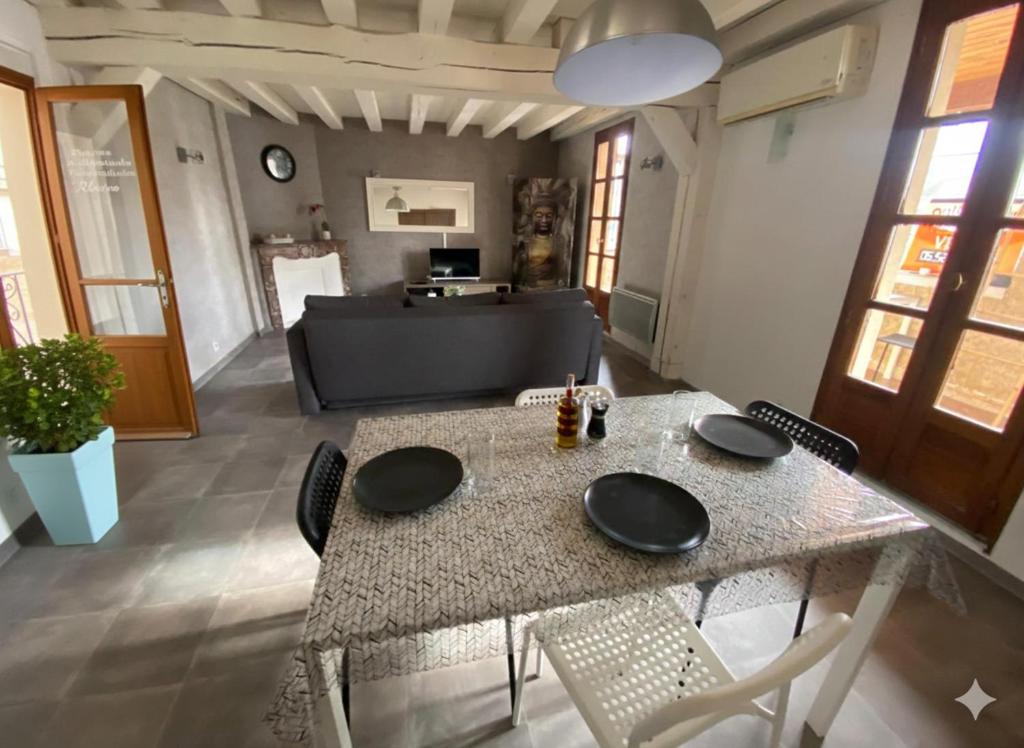 a dining table and chairs in a living room at Appartement plein centre wifi terrasse in Avignon