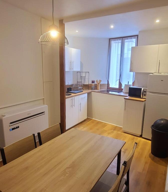 een keuken met een tafel en een eetkamer bij Au deuxième in Nogent-sur-Seine