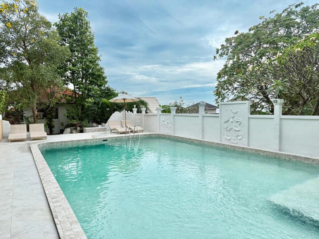 ein Pool mit einem Zaun und einem Sonnenschirm in der Unterkunft Bounty Resort in Haad Son