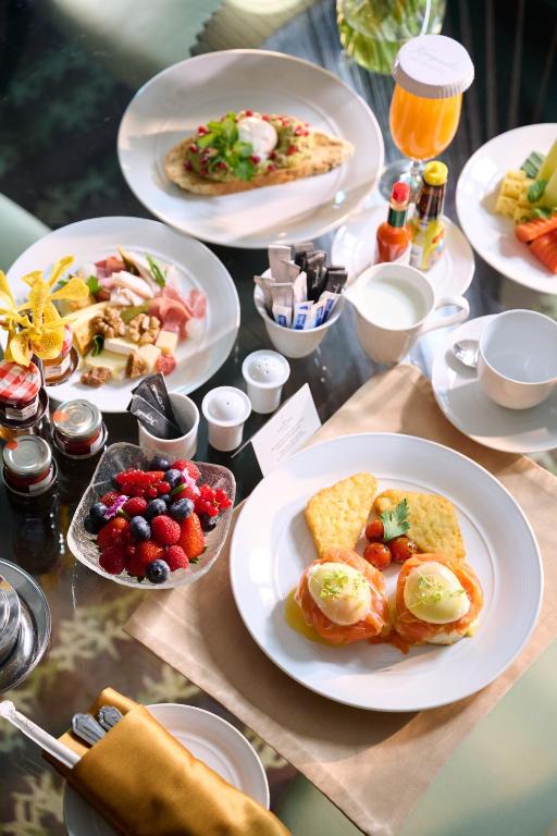 A bright breakfast spread of eggs, pastries, fruit, toast, and hot drinks.