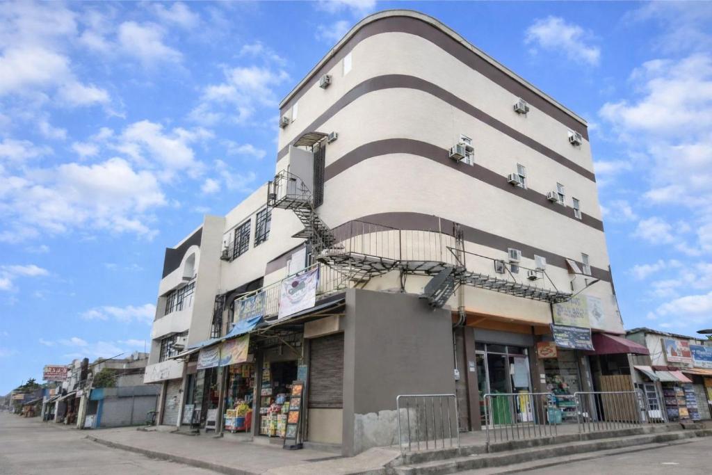 un alto edificio bianco con balconi su una strada di Zia Suites a Bugo