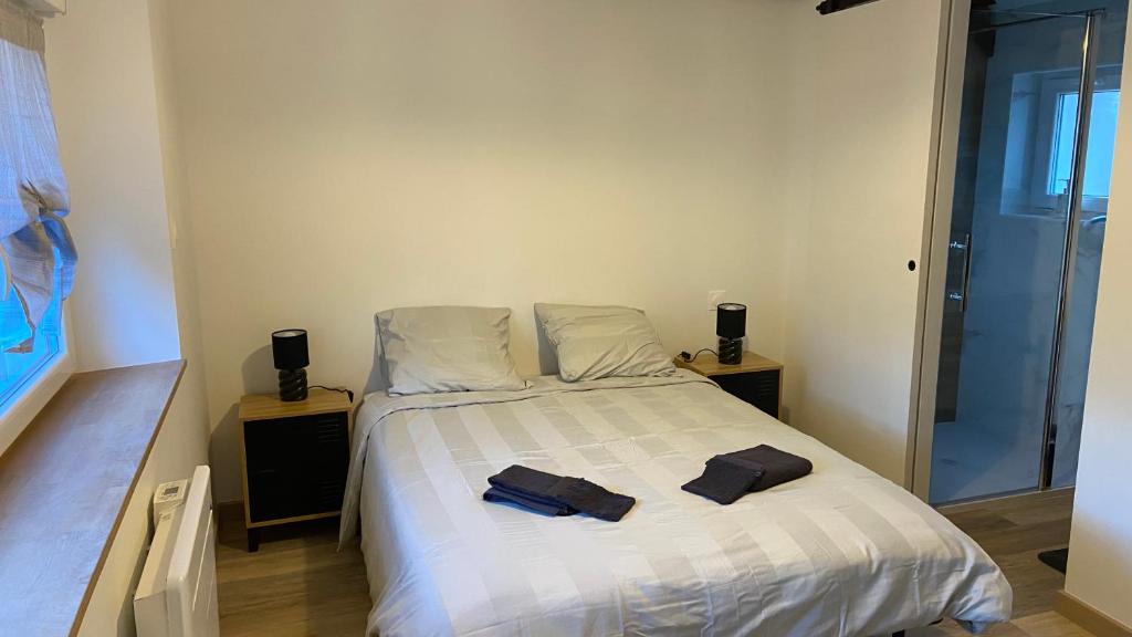 een slaapkamer met een bed met twee handdoeken erop bij Maison calme in Pleumeleuc