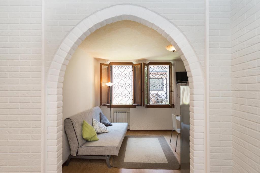 an arched hallway with a couch and two windows at Venice Biennale Garibaldi in Venice