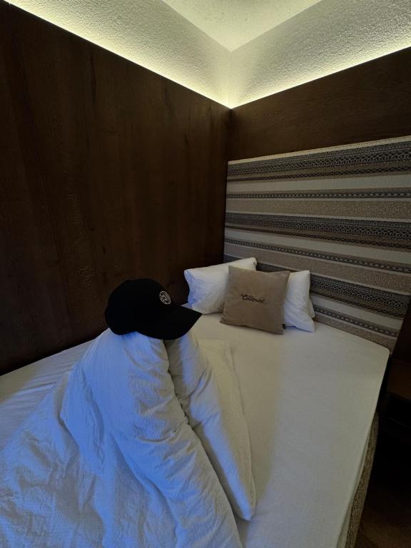 een bed met een zwarte hoed erop bij Hotel Central in Ischgl