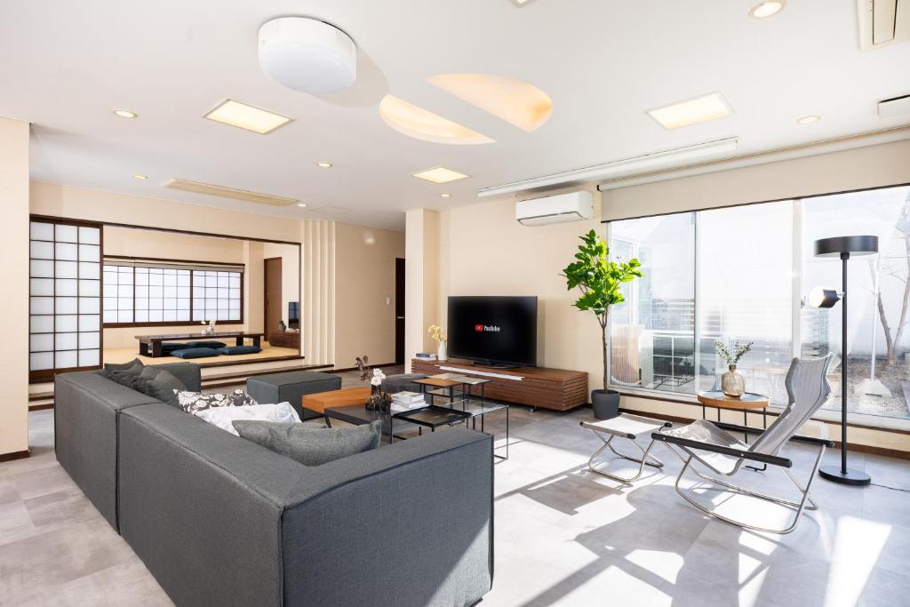 a living room with a couch and a tv at Bijou Suites AI PREMIUM in Osaka