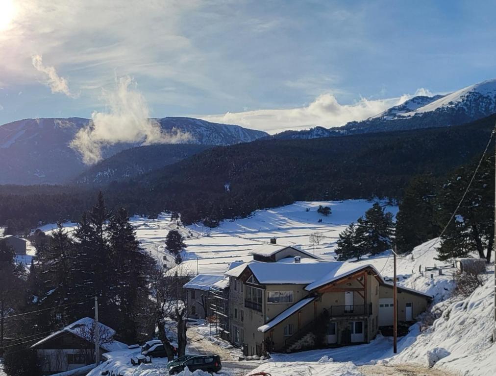 a ski lodge in the snow with mountains in the background at Le Calmadou in Formiguères