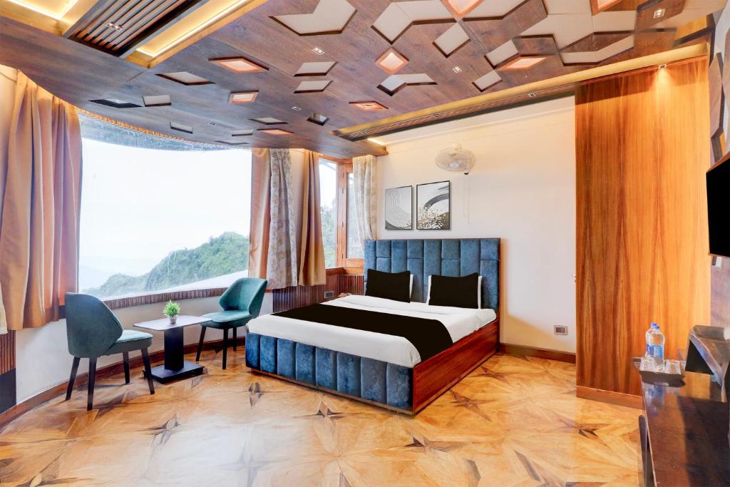 een slaapkamer met een bed, een tafel en stoelen bij Hotel O Siris Luxury Cottage Amatra Dunsvirk Court in Mussoorie
