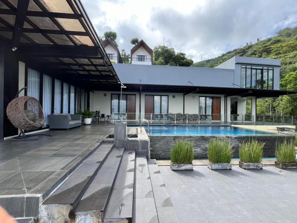 ein Haus mit einem Swimmingpool im Hof in der Unterkunft Anemos Resort By Tamastu in Pasirpogor