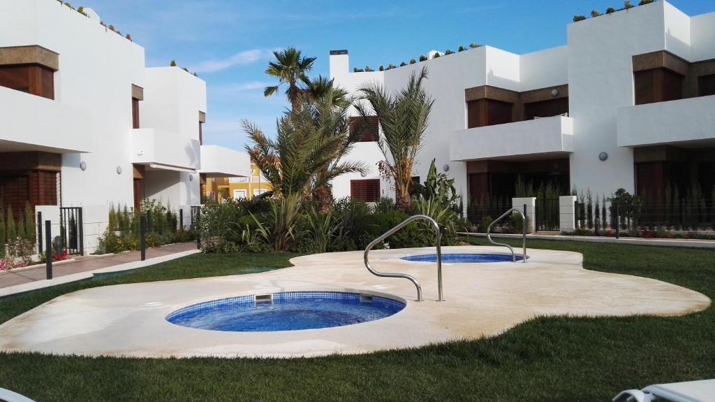 a hot tub in the middle of a yard in front of a building at 4daughters Secreto de la Zenia in Playas de Orihuela