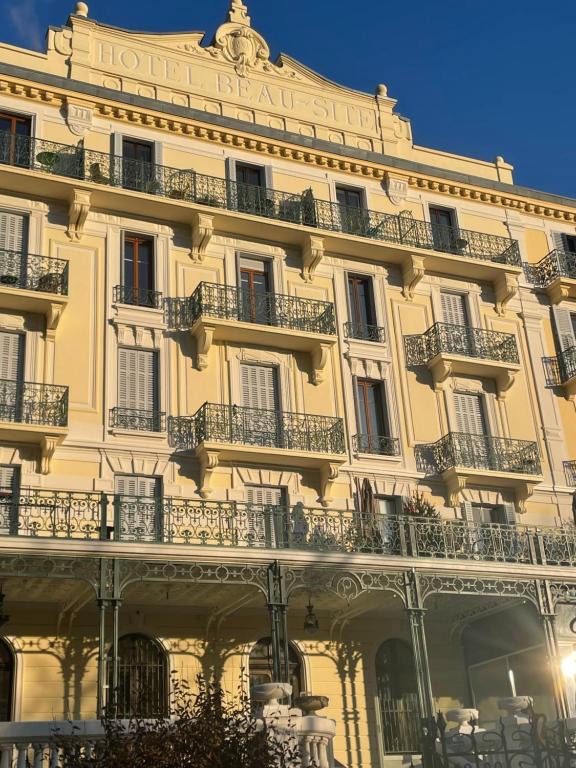 ein großes Gebäude mit Balkonen an der Seite in der Unterkunft Le 112, confortable et cosy en plein centre d'Aix les Bains in Aix-les-Bains