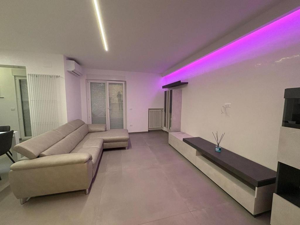een woonkamer met een bank en paarse verlichting bij B&B Relais in Francavilla al Mare