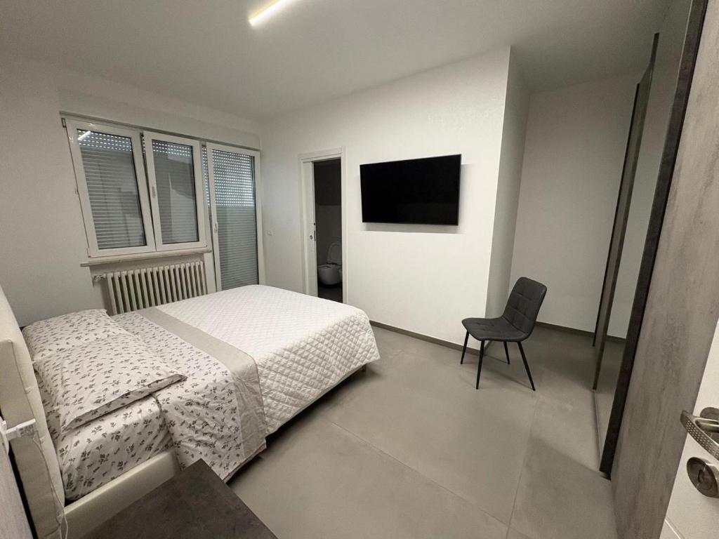 een slaapkamer met een bed, een stoel en een televisie bij B&B Relais in Francavilla al Mare