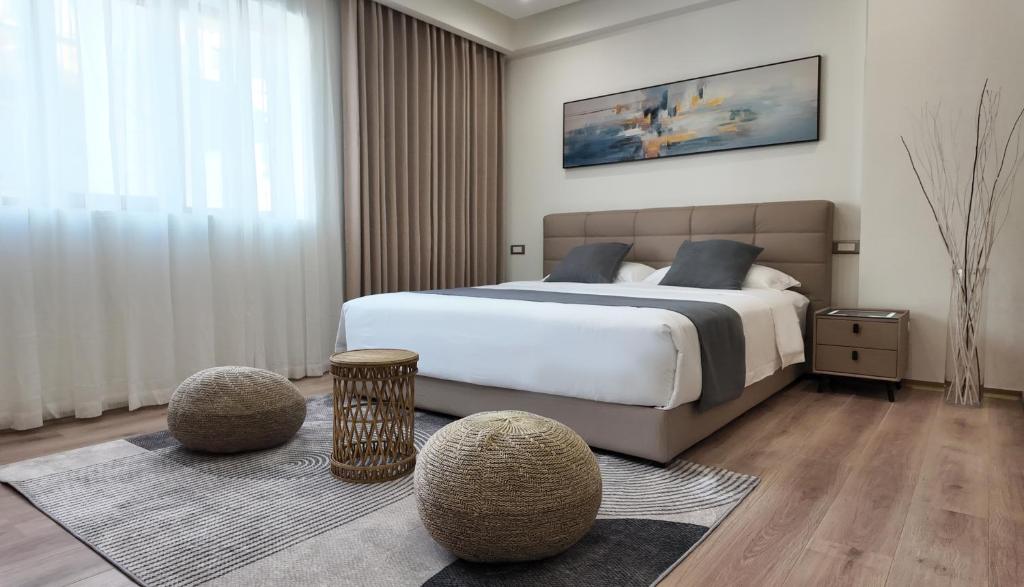 - une chambre avec un grand lit et 2 ottomanes dans l'établissement CC LUX Suites in Piraeus Port, au Pirée