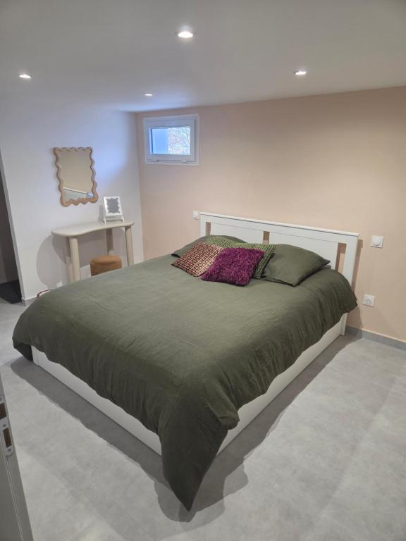 een slaapkamer met een groot bed in een kamer bij Les Noisetiers appartement in Saint-Just-Malmont