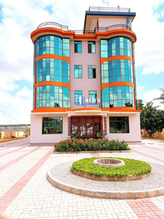 a large building with a circle in front of it at Rejis Hotel in Dodoma