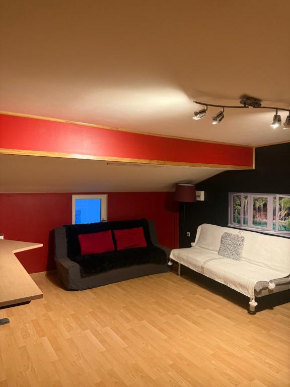 Zimmer mit 2 Betten und einer roten Wand in der Unterkunft Maison de village , terrasse et spa in Dourgne