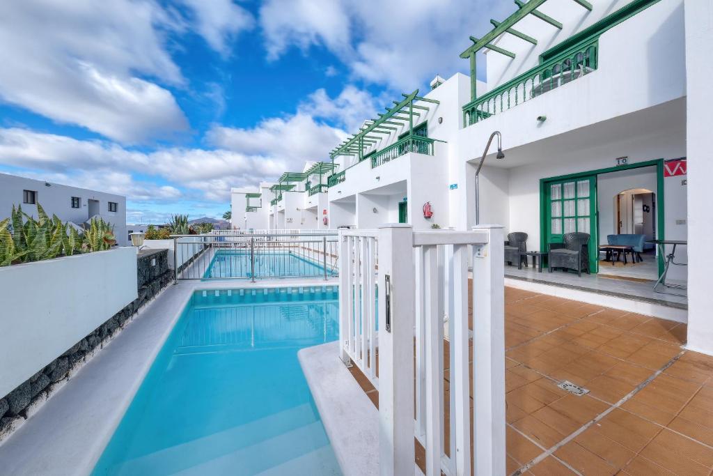 uitzicht op het zwembad vanaf het balkon van een huis bij Carpe Diem - Shared Pool By Lanzarote Vacation Homes in Puerto del Carmen