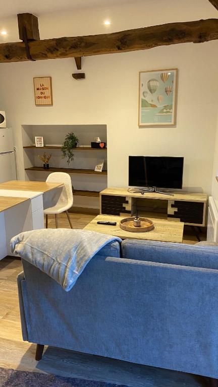 a living room with a blue couch and a tv at Charmante maison in Pleumeleuc