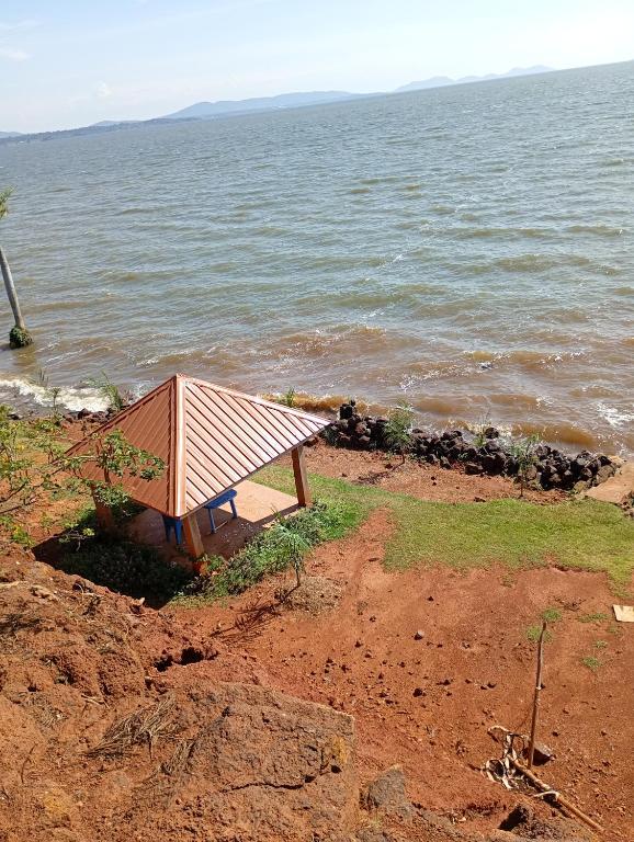 a picnic table on the beach near the water at The Lakeside Beach Hotel in Busia