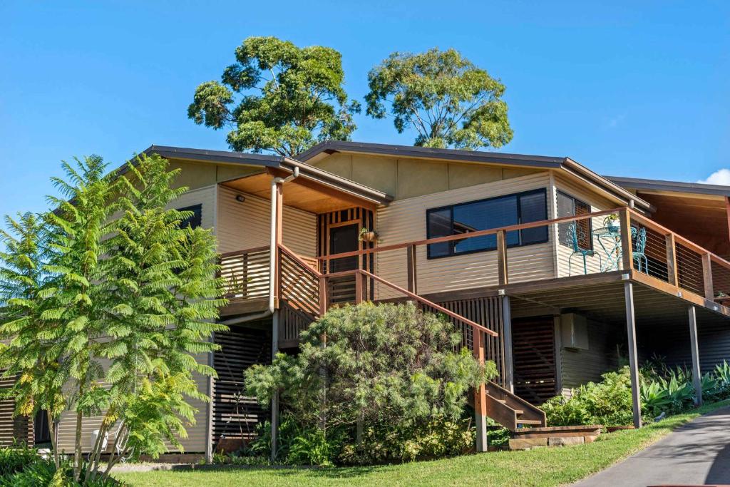 een groot huis met een balkon en bomen bij Narrawallee Oasis in Narrawallee