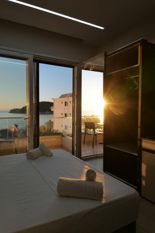 een slaapkamer met een bed met uitzicht op de oceaan bij The Blue Wave Hotel in Himare