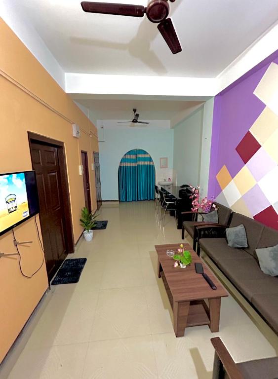 a living room with a couch and a ceiling fan at Letstay in Guwahati
