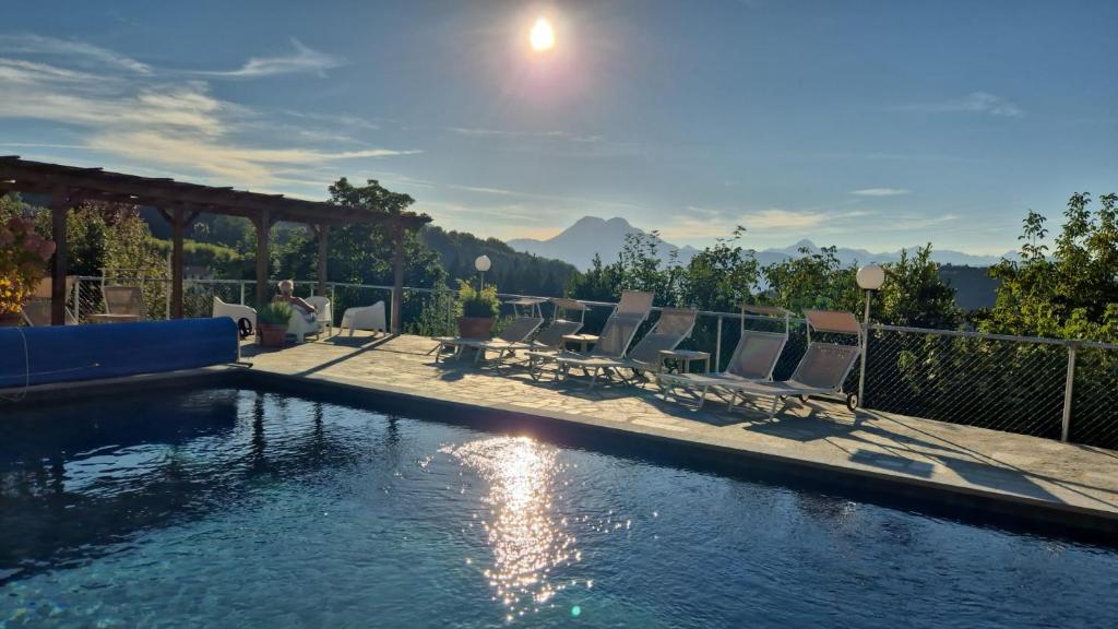 een zwembad met ligstoelen naast een hek bij Villa Pavone in Coreglia Antelminelli
