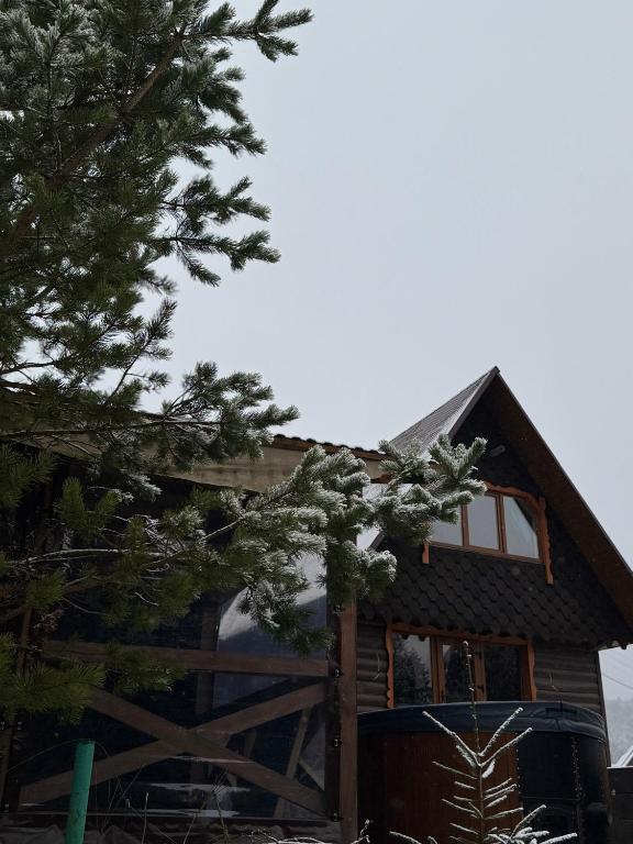 a house with a wooden gate and a tree at Spadok Forest Villas - Villa 2 in Sloboda