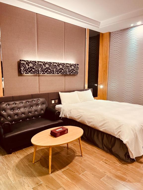 a bedroom with a bed and a couch and a table at Yunlin hotel in Tuku