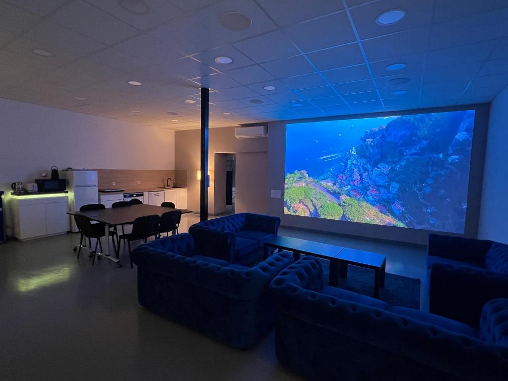 a large screen in a room with couches and a table at Loft 200m2 avec écran led géant de 10m2 in Marseille