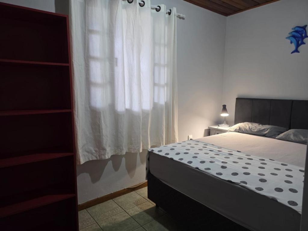 een slaapkamer met een bed en een raam bij Armação - Florianópolis - 2 quartos de casal in Florianópolis