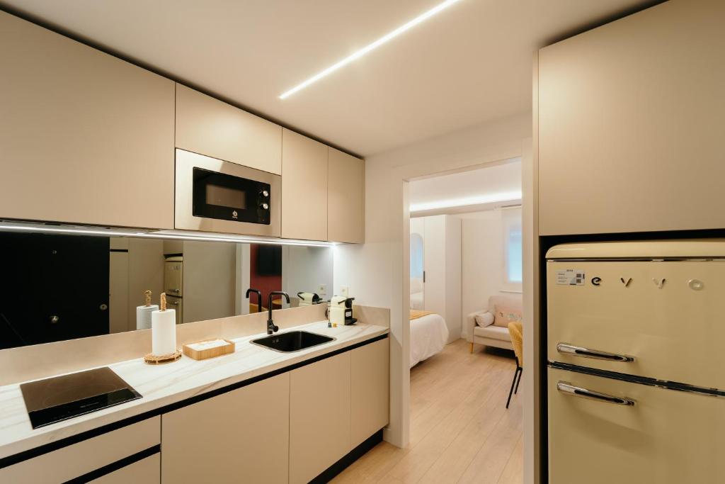 een keuken met witte kasten en een koelkast bij Fuente H1 in Jaén