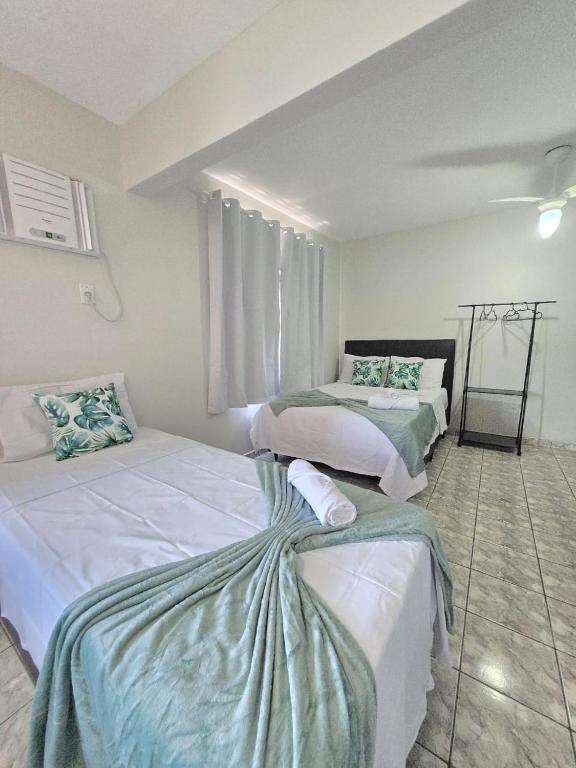 a room with two beds in a room at Loft Recanto Dos Cavalheiros! Com Ar Condicionado! in Macaé