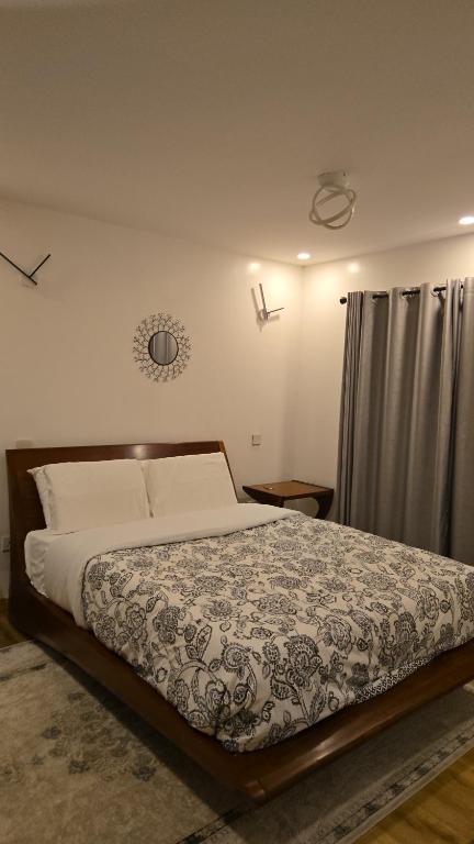 a bedroom with a large bed with a curtain at Venus Apartment in Nairobi
