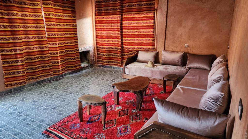 a living room with a couch and two stools at Atlas lodge in Sidi Hassaïn